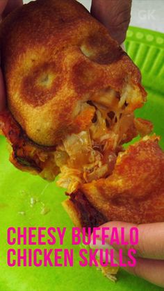 a person is holding up a cheesy breaded chicken roll on a green plate