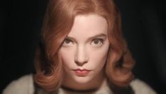 a woman with red hair is looking at the camera