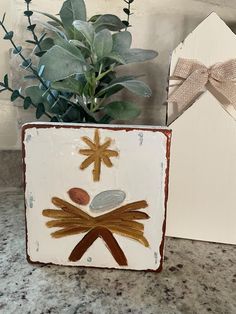 a plant in a pot sitting next to a white box with a design on it