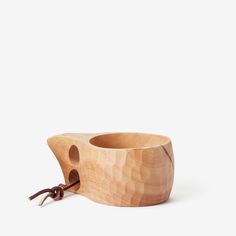 a small wooden bowl with a brown cord