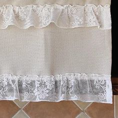 a kitchen curtain with lace on the edge