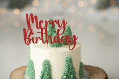 a cake that is sitting on top of a tree stump with the word santa baby spelled in red