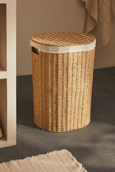 a wicker basket sits on the floor next to a shelf