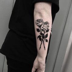 a woman with a black rose tattoo on her arm