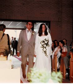 a bride and groom walking down the aisle