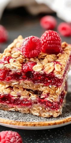 raspberry granola bars stacked on top of each other with fresh raspberries