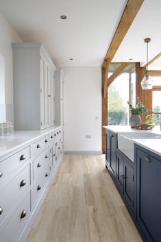 Wood effect porcelain planks in a navy kitchen with oak beams. Porcelain Wood Tile Kitchen, Quorn Stone, Wood Effect Floor Tiles, Porcelain Wood Tile, Country Cottage Kitchen, Herringbone Wood, Wood Floor Kitchen, Pale Wood