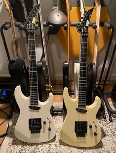 two electric guitars sitting next to each other on top of a counter in a room