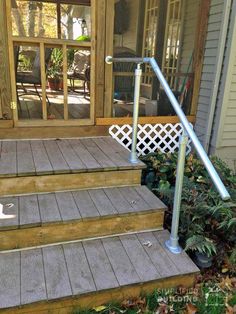 a cat is sitting on the steps in front of a house with an open door