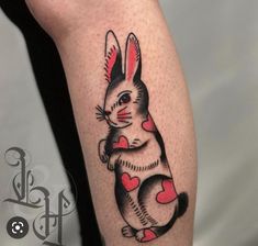 a rabbit tattoo with hearts on its leg