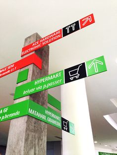 there are many signs on the pole in this building that is pointing to different locations