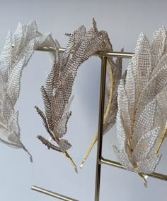 three silver and gold leaves on a metal stand