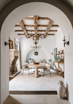 an archway leading into a living room with white walls and furniture on either side of it