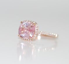 a pink diamond ring on a white surface