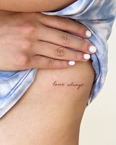 a woman's stomach with the word love always written on it and her hand resting on top of her belly