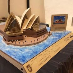 a model of the sydney opera house is on display in front of a card board