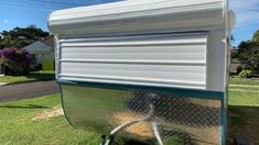 a white trailer parked on top of a lush green field