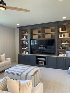 a living room filled with furniture and a flat screen tv on top of a wooden entertainment center