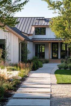 a white house with lots of windows and grass in front of the walkway leading up to it