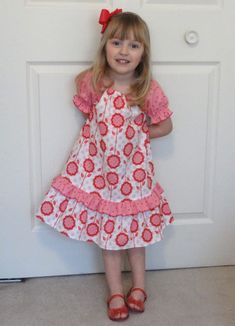 So sweet and girly, this little peasant-style dress looks great for any occasion and is super comfy to wear.  Cased elastic at the neckline and puff sleeves makes it easy to pull on.  A full flounce at the hemline is accented in a contrasting print to match the sleeves.  I can make this dress in sizes 1-6.  You may choose the Andalucia prints shown here in the model or select other prints from my stash of fabrics.  Your child's size and length measurement will be needed when ordering. Spring Peasant Dress With Ruffles, Short Sleeve, Peasant Style Dress, Twirl Skirt, Baptism Gown, Peasant Style, Peasant Dress, Linens And Lace, Flower Dresses, Western Outfits