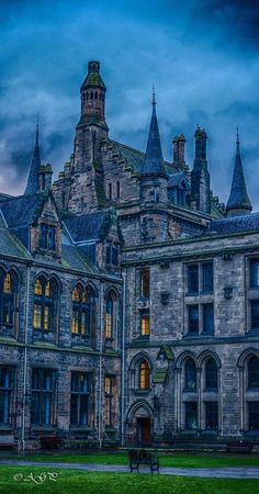 an old building with many windows and towers on it's sides at night time