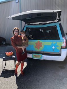 a woman and child standing in front of a van