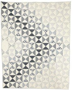 a black and white quilt with triangles on it's sides, in the shape of squares