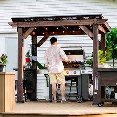 a man standing in front of an outdoor grill with lights on the side of it