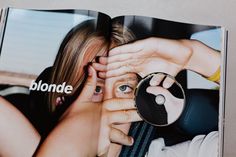 an open magazine with a woman holding a magnifying glass in front of her face