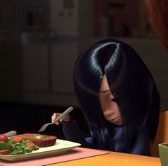 a woman sitting at a table with a plate of food in front of her