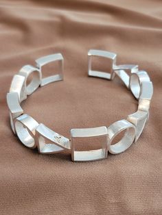 The bracelet is geometric style with .25 inch circles, squares, and triangles.  Solid 925 silver filled. Cool Silver Bracelets, Silver Cuff Bracelet For Women, Modern Sterling Silver Jubilee Bracelet With Rectangular Links, Sterling Silver Jubilee Cuff Bracelet, Unique Silver Geometric Jewelry, Modern Sterling Silver Rectangular Bracelet For Formal Events, Modernist Geometric Jewelry For Formal Occasions, Modern Sterling Silver Bracelet With Rectangular Links, Adjustable Silver Geometric Jewelry