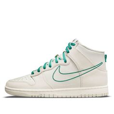 Nike Dunk HI SE is a special edition shoe from the First Use Pack celebrating Nike's 50th anniversary. It features an off-white leather upper with tonal suede overlays, a green leather Swoosh on the medial side, and a retro Swoosh outlined in green embroidery on the lateral side. It also has double-up laces in white and green, and a Swoosh-shaped lace jewel in a gleaming metallic gold finish. (SNKR/Skate/Men's/Casual/High Top) Cheap Dunks, Green Noise, Dr Shoes, Nike Models, Baskets Nike, Nike Dunk High, Dunk High, Sneakers Addict, Nike Sb Dunks