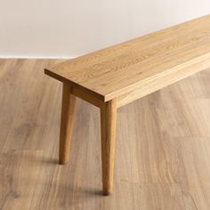 a wooden bench sitting on top of a hard wood floor