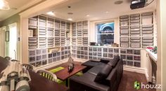 a living room filled with lots of furniture next to a wall covered in bookshelves