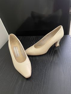 In excellent vintage condition. Shows some minor wear on the insole near the toe tip.  Heel tip shows little wear. Heel is 2 7/8". Classic Cream Closed Toe Court Shoes, Classic Fitted Court Shoes With Almond Toe, Cream Fitted Court Shoes With Round Toe, Classic Cream Heels, Fitted Cream Court Shoes With Round Toe, Classic Fitted Cream Heels, Vintage Fitted Court Shoes With Padded Heel, Cream Fitted Almond Toe Court Shoes, Fitted Cream Almond Toe Court Shoes