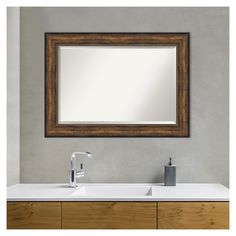 a bathroom vanity with a mirror above it and a faucet on the side