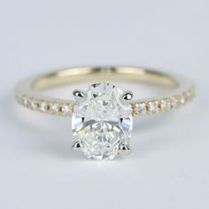 an oval cut diamond ring with pave set shoulders