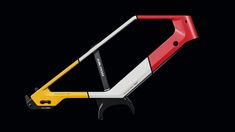 a red, white and yellow bike frame on a black background with the handle extended