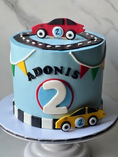 a blue cake with cars on it and the number 2 is for aaron's 2nd birthday