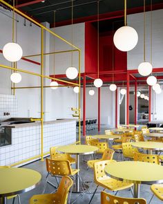 an empty restaurant with yellow tables and chairs