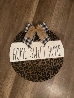 a sign that says home sweet home on top of a leopard print box with a bow