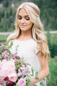 a beautiful blonde woman holding a bouquet of flowers