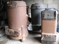 three old stoves sitting next to each other in a garage