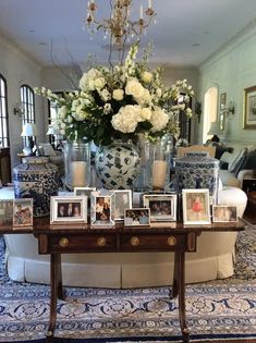 a living room filled with lots of furniture and flowers on top of a coffee table