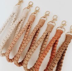 six different colored rope key chains hanging from hooks