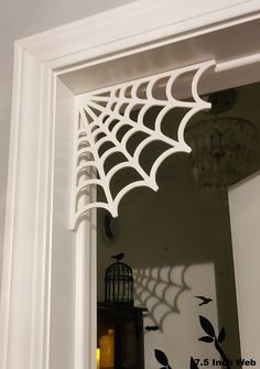 a spider web hanging from the side of a door with a birdcage on it