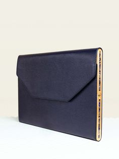 a blue clutch bag sitting on top of a white table