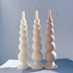 three tall white vases sitting next to each other