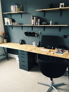 a computer desk with shelves on the wall