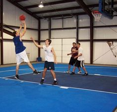 young men playing basketball in an indoor gym